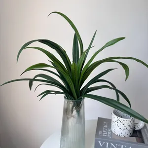 Detailed view of realistic artificial orchid leaves in a fluted glass vase for decor