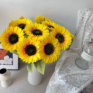 Lebendiger künstlicher Sonnenblumenstrauß in einer weißen geriffelten Vase für Deko
