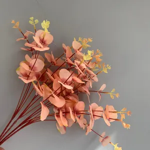 Close-up of artificial eucalyptus leaves with peach and yellow gradient colors