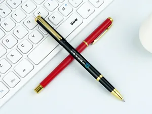 Macro view of a black metal business pen with custom logo printing on a white keyboard