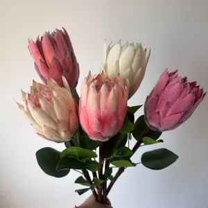Primer plano de proteas reales artificiales flocadas en tonos rosas y crema