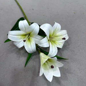 Detailed view of artificial white lily blossoms with realistic green leaves and buds.