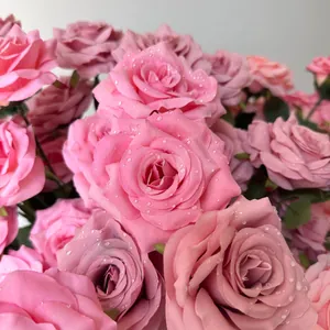 Close-up of pink artificial roses with realistic water droplets for wedding decor