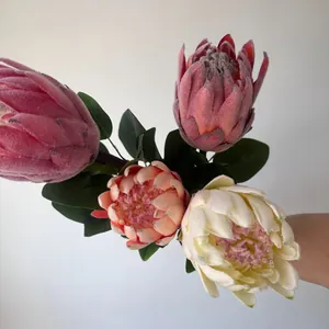 Vista detallada de flores de protea artificiales con textura de terciopelo y colores