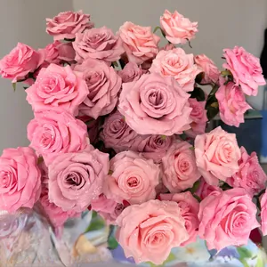 Detailed view of pink artificial roses featuring realistic water droplets on soft petals