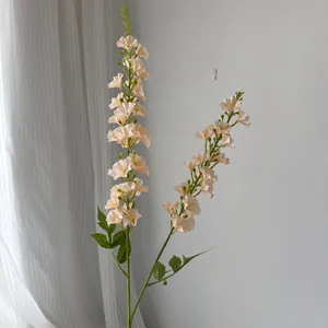 Vue détaillée de deux tiges de fleurs de delphinium artificielles abricot pour le décor