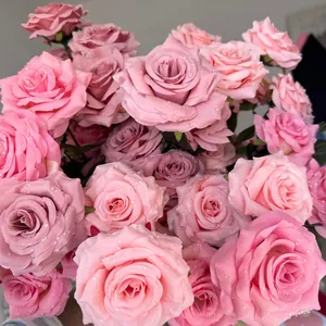 Close-up detail of realistic pink silk roses featuring decorative water droplets