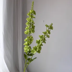 Gros plan d'une branche de delphinium artificielle verte pour décoration florale.