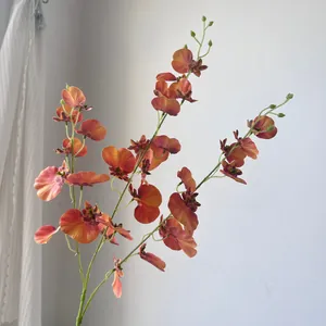 Detailed view of vibrant orange artificial Dancing Lady Orchids with realistic petals