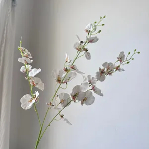 Detailed close-up of white artificial Oncidium orchid petals with realistic brown spots
