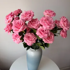 Detailed close-up view of elegant pink artificial roses with water droplets in a blue vase