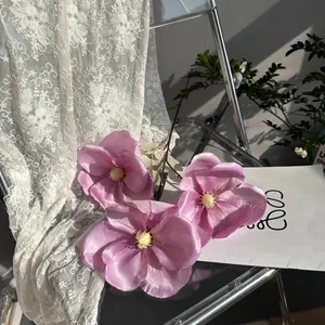 Detailansicht von drei rosa Seidenmagnolienblüten an einem Dekozweig