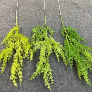 Detailed view of artificial fern branches in three shades of green for wedding decor.