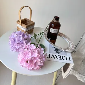High-quality pink and purple artificial hydrangeas arranged on a white table as decor.