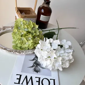 Close-up of white and green artificial hydrangea flowers on a decorative table