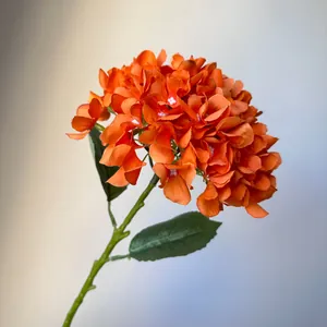 Detailed view of a vibrant orange artificial hydrangea flower for home or wedding decor.