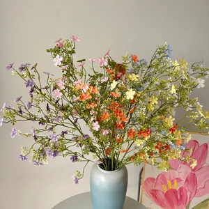 Detailansicht bunter künstlicher Schleierkraut-Wildblumen in einer blauen Vase als Deko