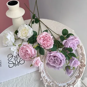 Multi-color artificial Austin roses arranged on a vintage lace tablecloth.