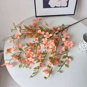 Vue détaillée d'une branche artificielle de fleurs orange Seven-Mile Fragrance sur table
