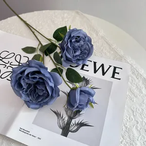Close-up of artificial blue Austin roses with silk petals on elegant magazine