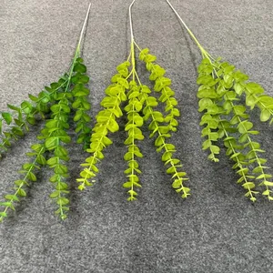 Detailed view of three shades of artificial green eucalyptus stems for wedding decor