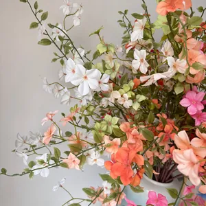 Gros plan de branches de fleurs d'oranger factices colorées dans un vase