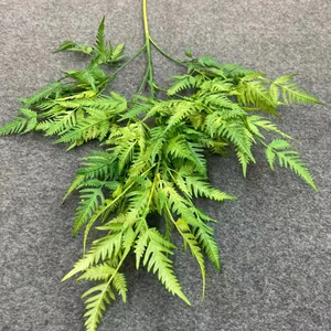 Close-up view of the realistic texture and green gradient of artificial fern leaves