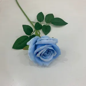 Detailansicht einer einzelnen künstlichen blauen Rose mit realistischen grünen Blättern