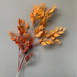Detailed view of orange spray-painted artificial banyan leaves for decor