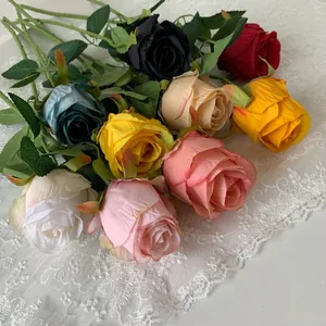 Macro detail of various colorful artificial Bulgaria roses arranged on elegant white lace