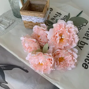 Detailed macro view of artificial peach peony bouquet featuring five lush flower heads