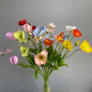 Vibrant colorful artificial poppy silk flowers in glass vase for home wedding party decor