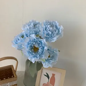 Detailed view of a light blue 5-head artificial peony bouquet in a ribbed glass vase