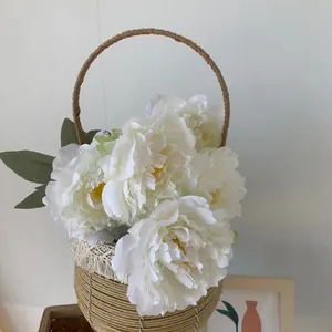 Close-up detailed view of white five-head artificial peony bouquet in woven basket