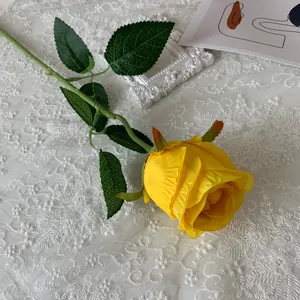 Detail view of a lifelike yellow artificial Bulgarian rose flower for home decor
