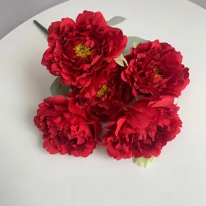 Close-up of five vibrant red artificial peony flower heads for wedding decor