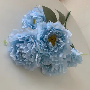 Detail of five light blue artificial peony heads in a decorative bouquet arrangement