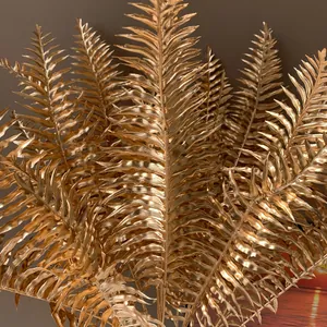 Detailaufnahme von künstlichen goldenen Farnblättern mit realistischer Metallic-Textur für Deko