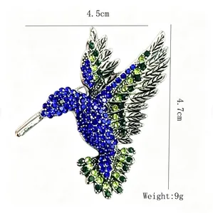 Vista dettagliata di una spilla a colibrì con strass colorati, dimensioni 4,5x4,7 cm.