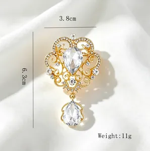 Detail view of a vintage crown brooch with sparkling rhinestones and teardrop pendant