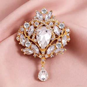 Vue macro détaillée d'une broche couronne vintage dorée avec des cristaux clairs