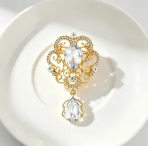 Detailed macro view of vintage palace style gold brooch with sparkling crystal water drop