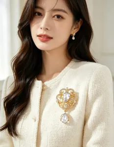 Detailed view of an ornate palace style crown brooch with clear pear-shaped drop crystal
