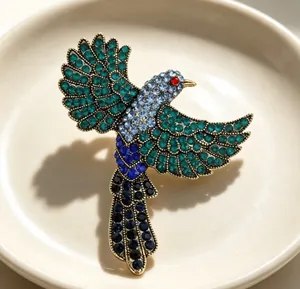 Detailansicht einer Vintage-Elster-Brosche mit funkelnden blauen und grünen Strasssteinen.