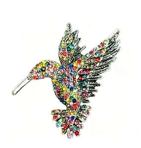 Primo piano di una vibrante spilla a colibrì con scintillanti strass multicolore.
