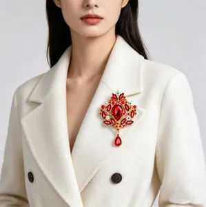 Détail d'une broche couronne en cristal rouge vintage sur un manteau de laine blanc