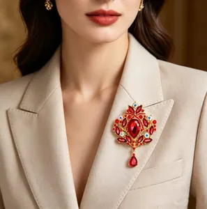 Détail d'une broche couronne vintage ornée de strass rouges sur un blazer beige élégant