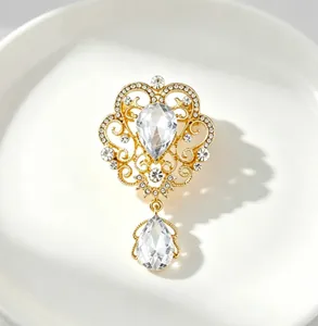 Detailed macro view of a vintage palace-style gold brooch with teardrop crystal pendants
