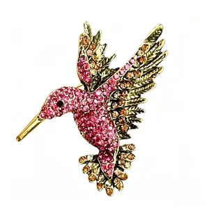 Vista dettagliata di una spilla a colibrì con strass vivaci e finitura oro antico