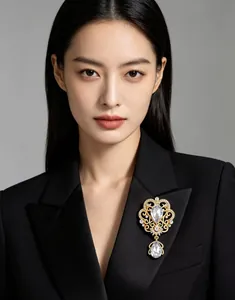 Ornate crown brooch with crystals and teardrop pendant shown on black blazer lapel